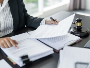 Close-up view of a person presumably a lawyer or legal professional reviewing documents at a desk | ASAP Bail Bonds Houston