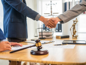 Close-up view of two people in business attire shaking hands across a wooden table | ASAP Bail Bonds Houston